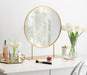Gold Finish Round Table Mirror with Metal Stand on vanity with makeup