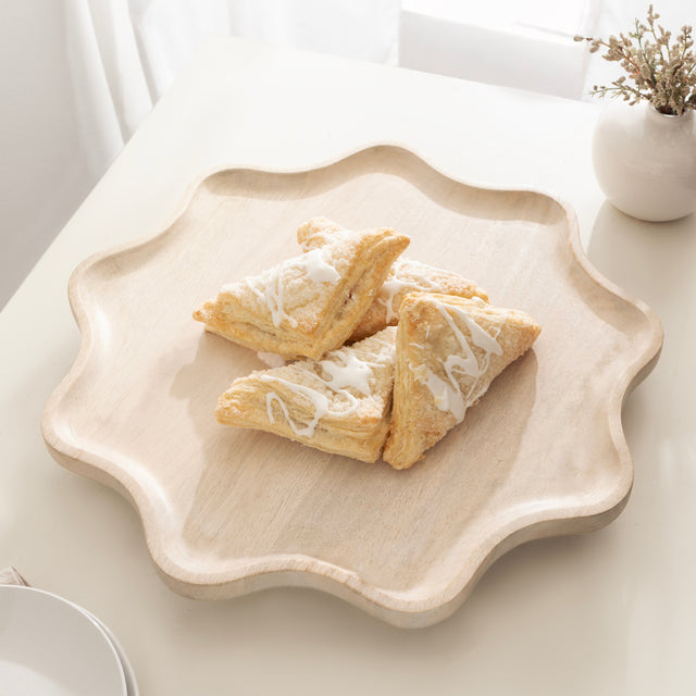 Three triangular pastries on a decorative plate with a white background